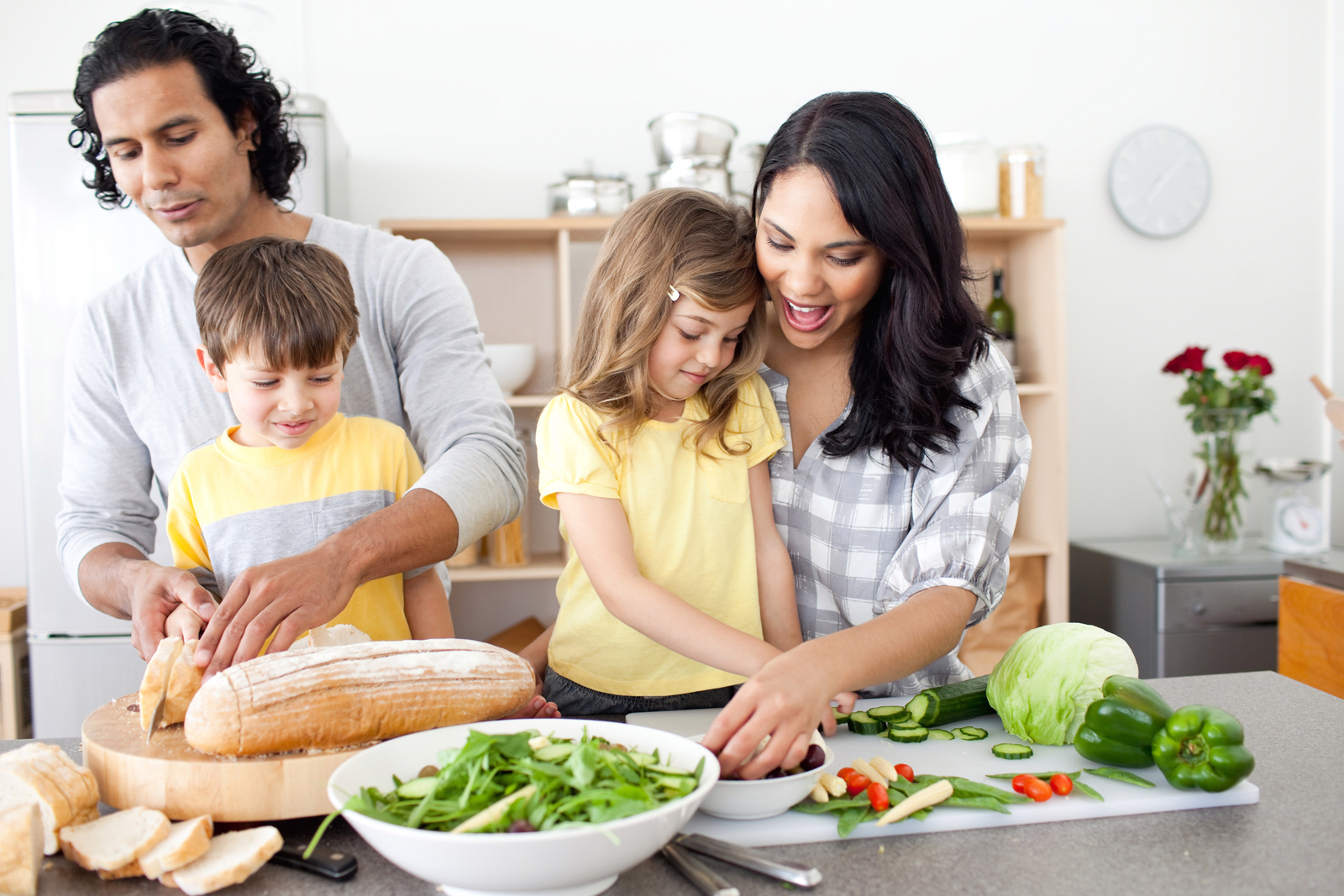 family cooking dinner together while laughing