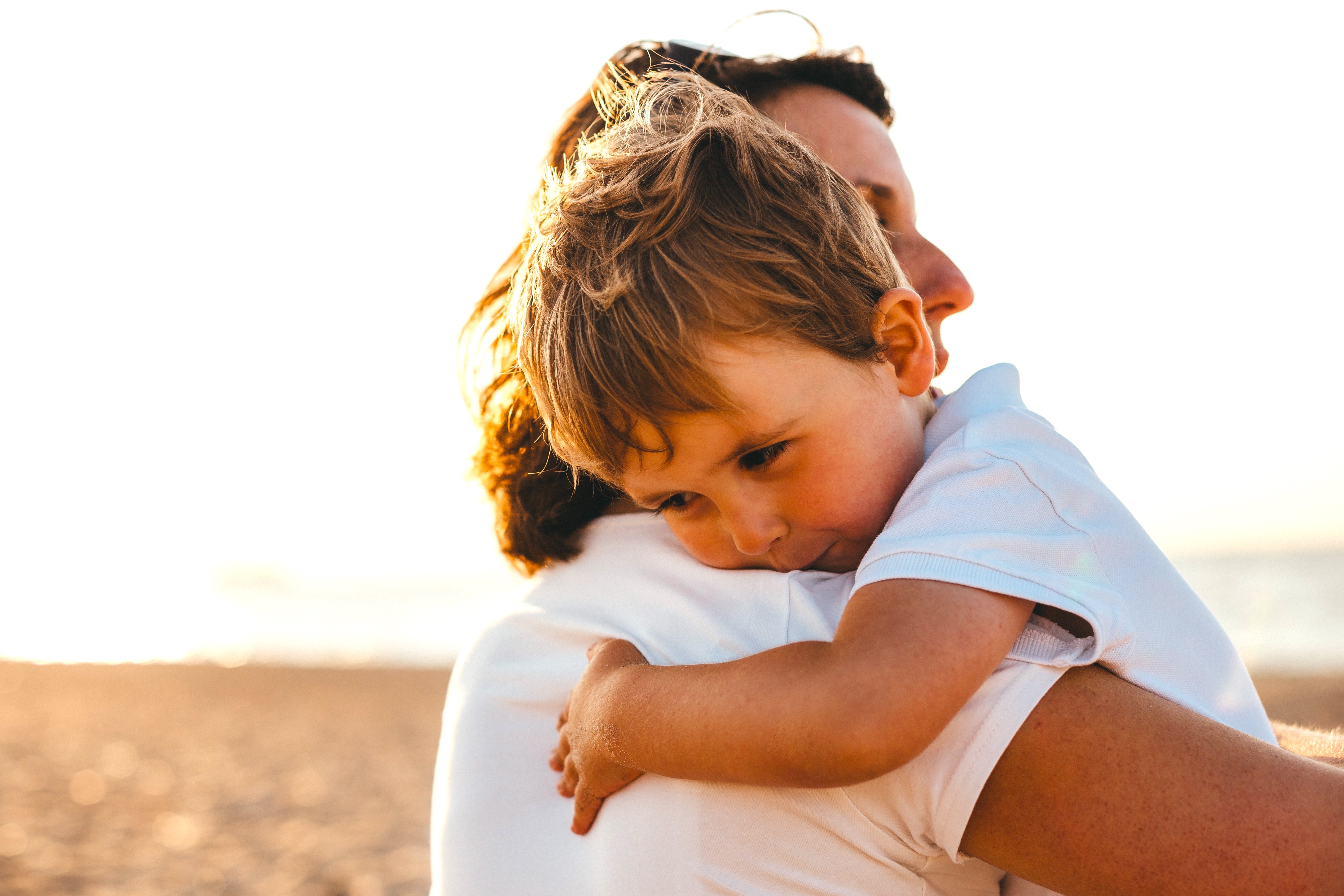 Mom hugging her son on the beach